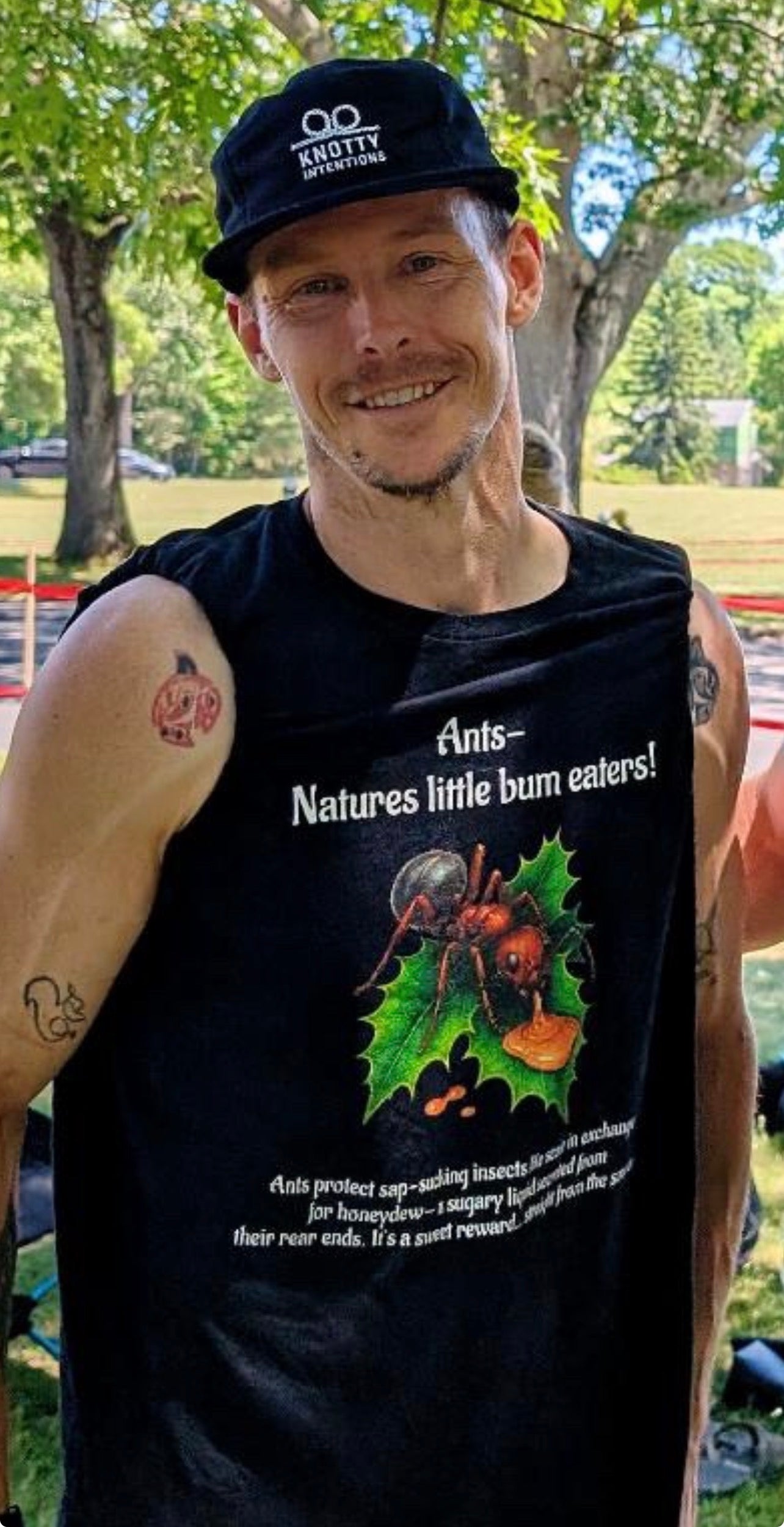 Knotty Intentions cap and Ant design worn outdoors on a sleeveless shirt.